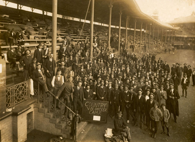 A group of men and boys from the ‘Country Volunteer Camp’ gathered in front of the Brewongle Stand at the Sydney Cricket Ground
